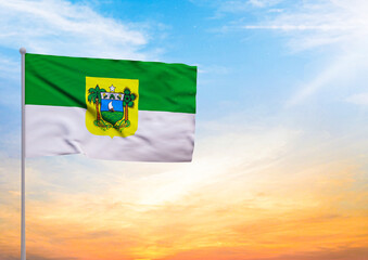 3D illustration of a Rio Grande do Norte flag extended on a flagpole and in the background a beautiful sky with a sunset - obrazy, fototapety, plakaty