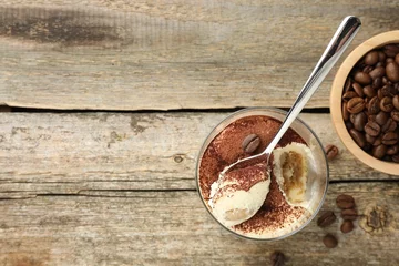 Fotobehang Delicious tiramisu in glass, spoon and coffee beans on wooden table, top view. Space for text © New Africa