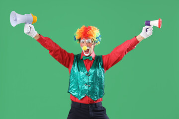 Portrait of clown with megaphones on green background. April Fool's day celebration