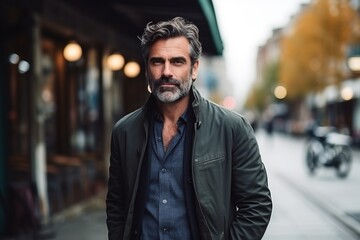Portrait of a handsome mature man in a city street. Men's beauty, fashion. - obrazy, fototapety, plakaty