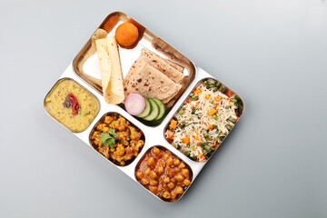 Assorted indian food for lunch or dinner, rice, lentils, paneer butter masala, palak panir, dal makhani, naan, green salad