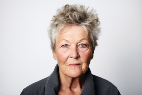 Portrait of a senior woman with grey hair on a gray background