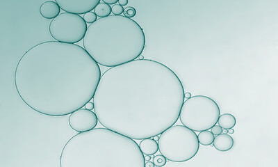Abstract oil and water droplets to create bubbles pattern with pale green background.