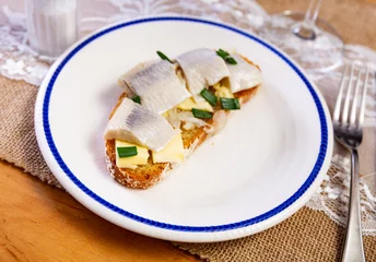 Fotobehang Appetizing sandwich with herring fillet and butter served on plate © JackF