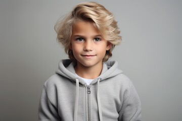 Portrait of a cute little boy in a gray hoodie.