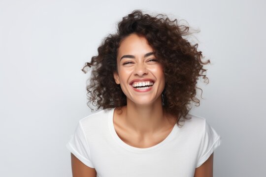 Portrait of beautiful young woman with curly hair smiling and looking at camera