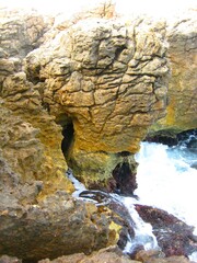 Waves crashing on seashore rocks, Top view sea surface waves background