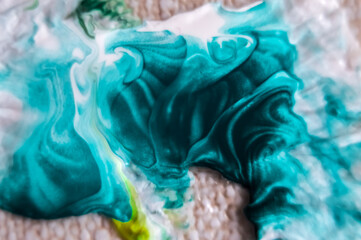 Close up of blue and white paint mixing in water, abstract background