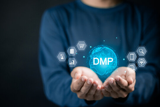 DMP, Data Management Platform concept. Marketing system for data management. Businessman holding globe with DMP icon on virtual screen for marketing and crm concept.