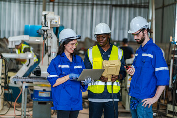 Artificial intelligence robotic technician concept, Factory engineer inspecting on machine with smart tablet. Worker works at heavy robot arm. Welding with remote system in an manufacturing industrial