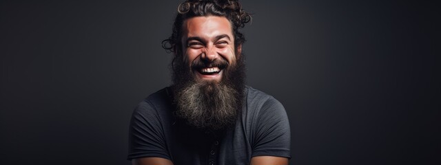 A bearded man laughs at the camera. Studio portrait in the background. space for text
