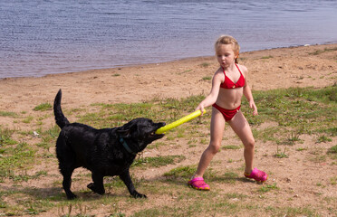 On a hot summer day, a beautiful girl is playing outside with a big dog.