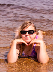 On a hot summer day, a child is relaxing on the lake. A girl on the beach.