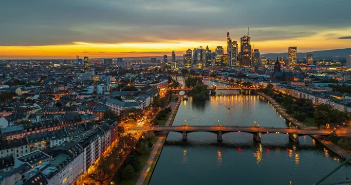 Aerial view Hyper lapse Footage of Frankfurt am Main skyline, though Main river and modern finance building and skyscrapers when sunset time, Germany