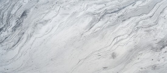 Fototapeta premium A detailed shot of a grey marble texture resembling freezing snow patterns on a winter slope, with furlike cumulus clouds in the background