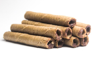 some chocolate wafer rolls on white background