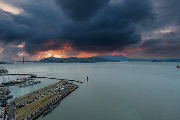 aerial shot of the Fisherman’s wharf, Aquatic Cove, the Golden Gate Bridge over the ocean water,...