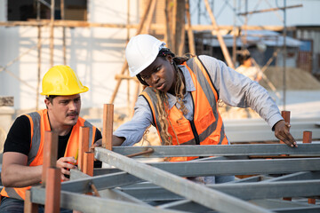Worker engineer African woman working with caucasian worker at construction site	 - 758590962