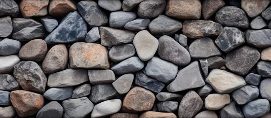  A closeup of a stack of cobblestone rocks, used as building material for walls or road surfaces. The natural pattern of the bedrock creates a unique and durable composite material © TheWaterMeloonProjec