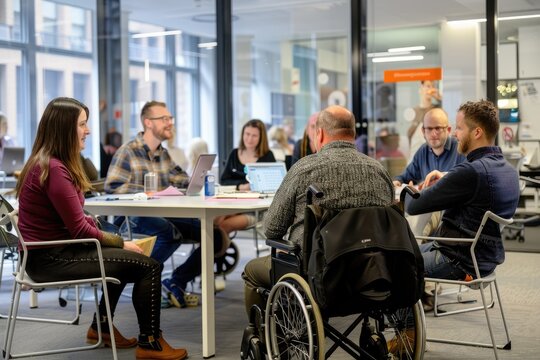 man in wheelchair sitting at desk in front of computer, working in office, Inclusivity