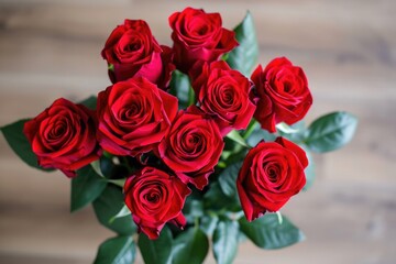 Bouquet of red roses is displayed on wooden table