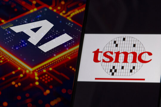TSMC (Taiwan Semiconductor Manufacturing Company Limited) logo on a smartphone screen, AI computer chip in the background.