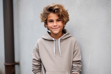 Portrait of a cute young boy with blond curly hair wearing hoodie