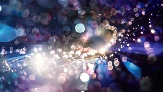 Underneath the distorted reflection of a bright light source droplets of magnetic fluid together in a curious dance of attraction and repulsion pulled in several directions
