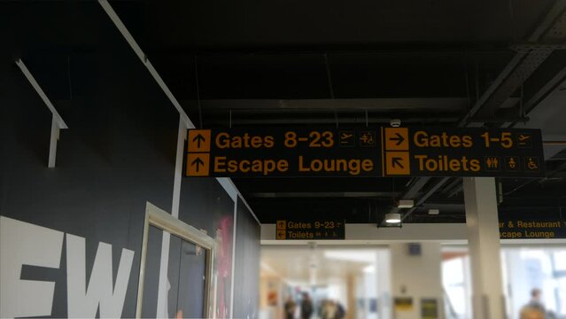 Busy airport sign interior with gates toilets and lounge bustling with travellers