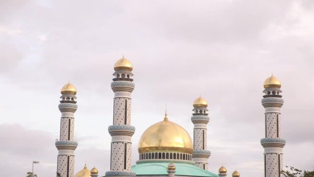 golden dome and minarets above tropical landscape at Jame' Asr Hassanil Bolkiah Mosque in Bandar Seri Bagawan in Brunei Darussalam