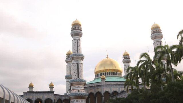 golden dome of mosque above tropical palm trees at Jame' Asr Hassanil Bolkiah Mosque in Bandar Seri Bagawan in Brunei Darussalam