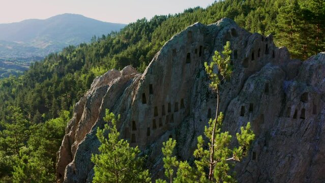 Retreating drone shot of the prehistoric beehive-like rock tomb chambers called the Eagles Rock also known as the Orlovi Skali situated in Rhodope Mountain in Bulgaria.