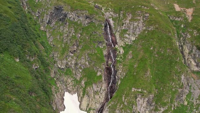 The valea rea waterfall cascading down fagaras mountains, lush greenery surrounding, aerial view