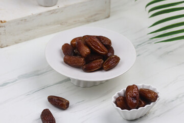 Kurma or Dates fruit on marble white background. Breakfasting concept in Ramadan month. Islamic template for text background.