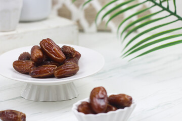 Kurma or Dates fruit on marble white background. Breakfasting concept in Ramadan month. Islamic template for text background.