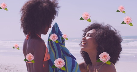 Image of flowers over happy african american mother with daughter on sunny beach