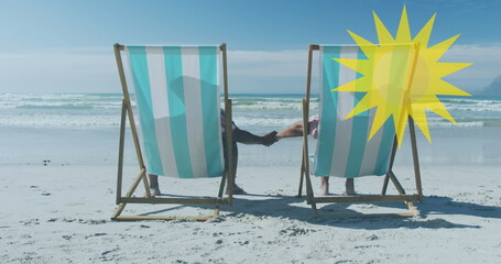 Image of sun over senior african american couple lying on sunbeds on sunny beach