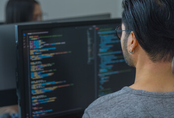 Asian prompt engineer developer coding app with software data sitting in front of computer monitor at office - 758622737