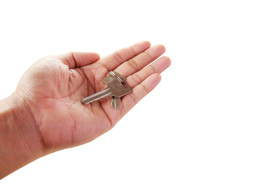 Human hand holding key to a dream house isolated on white