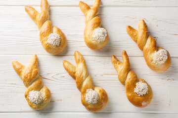 Easter bunny twist buns with coconut closeup on a white wooden background. Horizontal top view from...