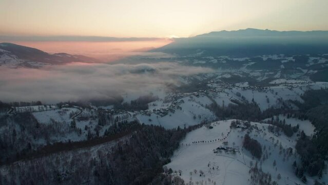 Sunrise over Pestera Village with mist, winter landscape, aerial view