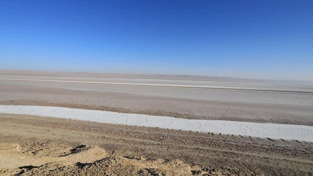 Vast salt flats under clear blue skies at Chott el Jerid, Tunisia, stark landscape