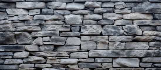 Fototapeta premium A detailed closeup of a stone wall constructed with gray bricks, showcasing the intricate pattern and texture of the brickwork as a building material