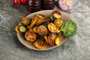 Roasted young zucchini in the plate