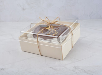 premium freshly baked dark cocoa chocolate brownie gold flower and earl grey peanut round birthday cake with walnut in wood bento box on white marble halal food sweet dessert menu for pastry cafe shop