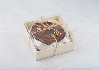 premium freshly baked dark cocoa chocolate brownie gold flower and earl grey peanut round birthday cake with walnut in wood bento box on white marble halal food sweet dessert menu for pastry cafe shop