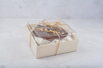 premium freshly baked dark cocoa chocolate brownie gold flower and earl grey peanut round birthday cake with walnut in wood bento box on white marble halal food sweet dessert menu for pastry cafe shop