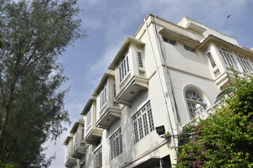 Charming White-Facade Building With Balconies and Greenery Under a Clear Sky at  Merwara estate Ajmer
