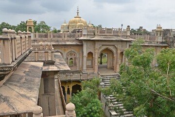 Fototapeta premium Majestic Royal Cenotaphs Amidst Verdant Greenery Under Cloudy Skies at Maharani Ki Chhatri ,Jaipur, Rajasthan, India