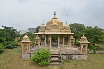 Fototapeta na wymiar Majestic Royal Cenotaphs Amidst Verdant Greenery Under Cloudy Skies at Maharani Ki Chhatri ,Jaipur, Rajasthan, India